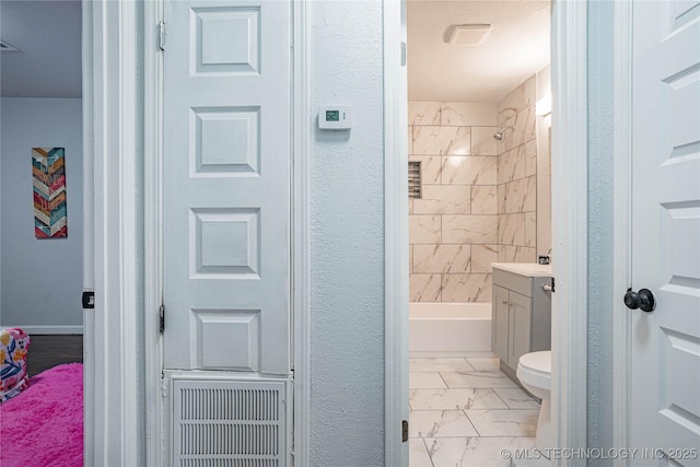full bathroom with vanity, tiled shower / bath, and toilet