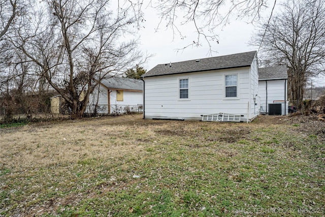 back of property featuring central AC unit and a yard