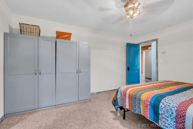 bedroom featuring ceiling fan, light carpet, and a textured ceiling