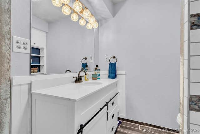 bathroom with hardwood / wood-style flooring, vanity, and a notable chandelier