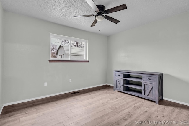 unfurnished room with ceiling fan, light hardwood / wood-style floors, and a textured ceiling