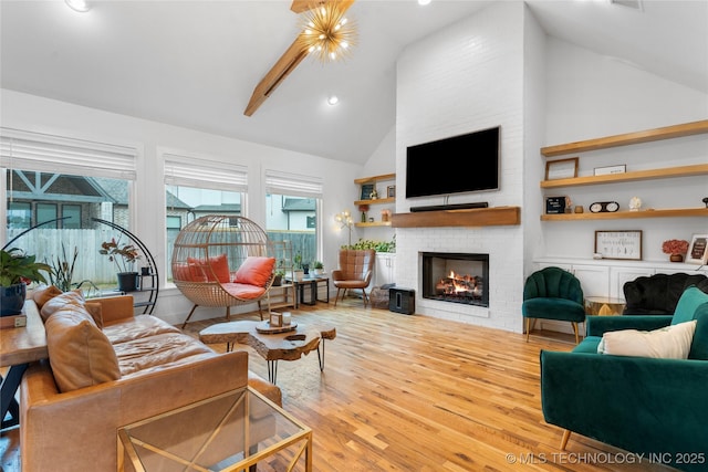 living room with a fireplace, high vaulted ceiling, and light hardwood / wood-style flooring