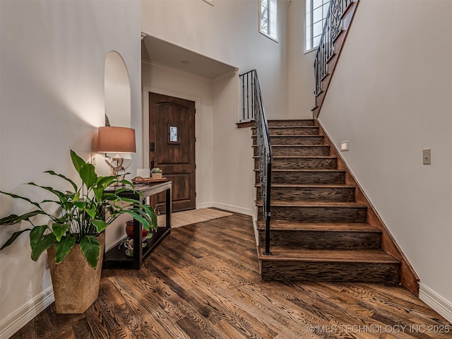 entryway with hardwood / wood-style flooring and a towering ceiling
