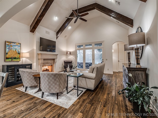 living room with ceiling fan, high vaulted ceiling, beamed ceiling, and dark hardwood / wood-style floors
