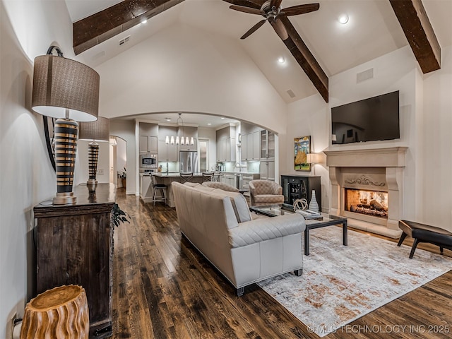 living room featuring high vaulted ceiling, dark hardwood / wood-style floors, and beamed ceiling