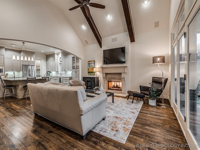 living room featuring ceiling fan, high vaulted ceiling, dark wood-type flooring, and beamed ceiling