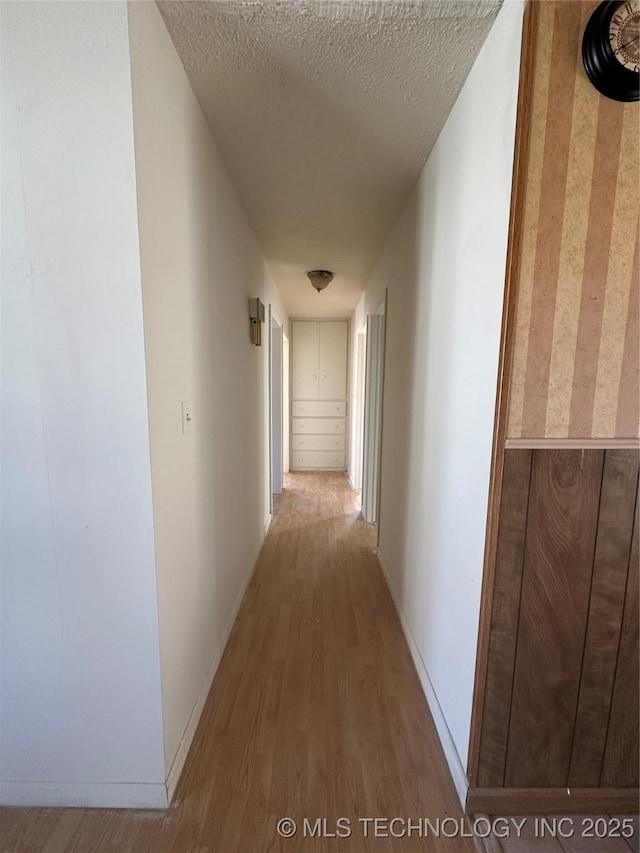 hallway featuring wood-type flooring and a textured ceiling