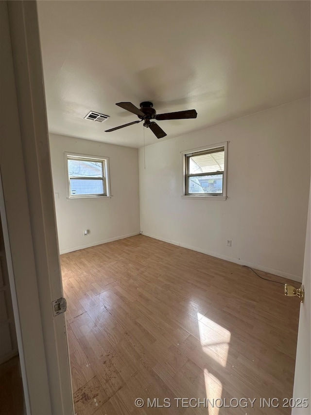 unfurnished room with a healthy amount of sunlight, ceiling fan, and light hardwood / wood-style flooring