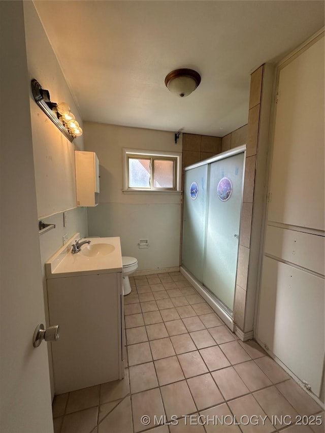 bathroom featuring vanity, toilet, tile patterned floors, and walk in shower