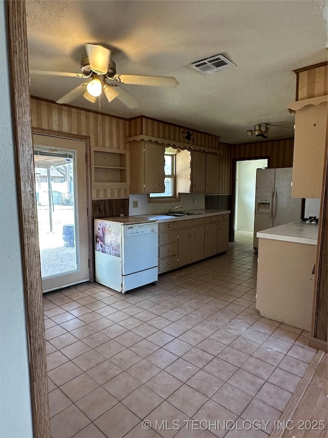 kitchen featuring a textured ceiling, plenty of natural light, dishwasher, and light tile patterned flooring