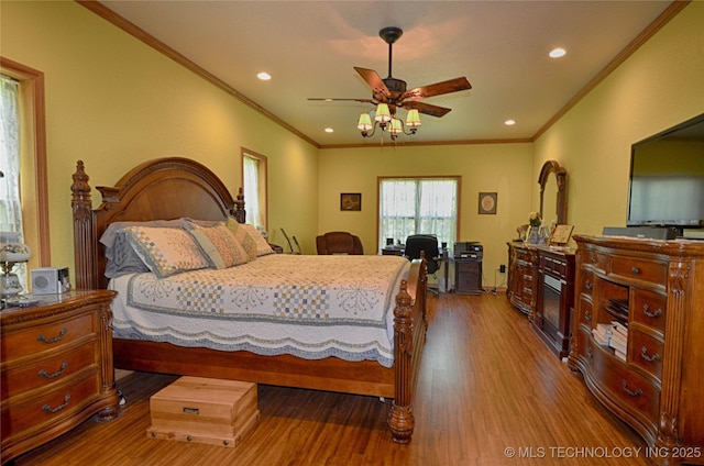 bedroom with wood-type flooring, ceiling fan, and crown molding