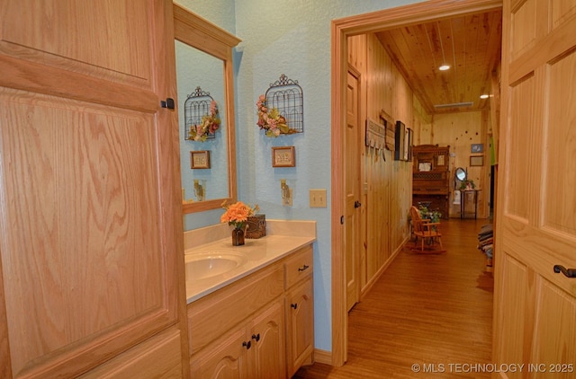 bathroom with hardwood / wood-style flooring, vanity, and wood ceiling