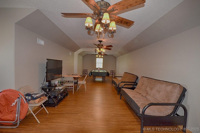 bedroom with vaulted ceiling, light hardwood / wood-style flooring, and a textured ceiling