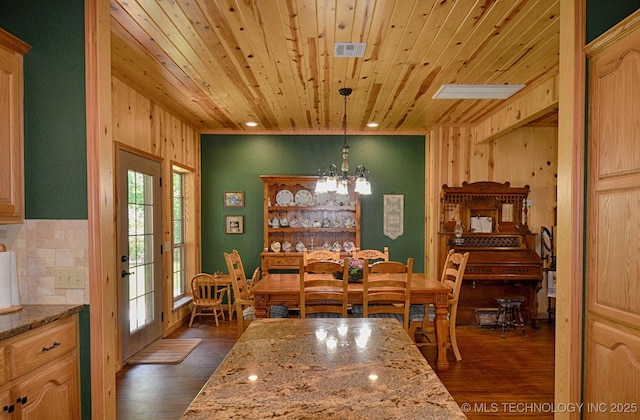 dining room with wood ceiling, wooden walls, dark hardwood / wood-style floors, and a chandelier