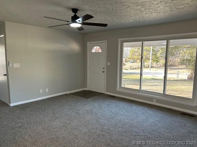 carpeted foyer featuring ceiling fan and a textured ceiling