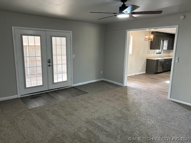 unfurnished living room with french doors, ceiling fan, and carpet