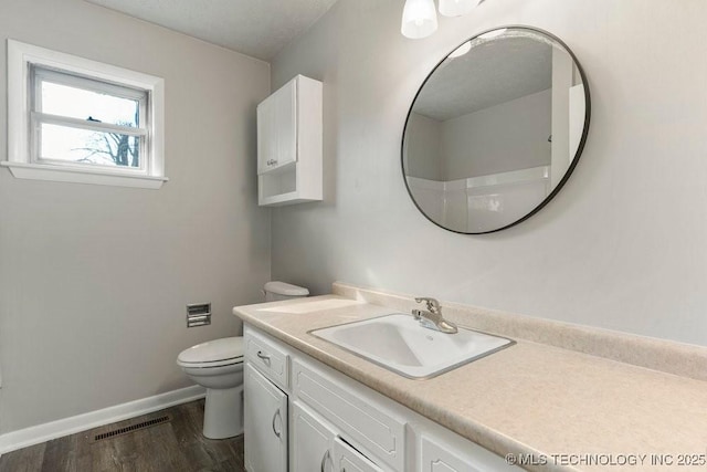 bathroom with vanity, wood-type flooring, walk in shower, and toilet