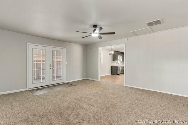 carpeted spare room featuring french doors and ceiling fan