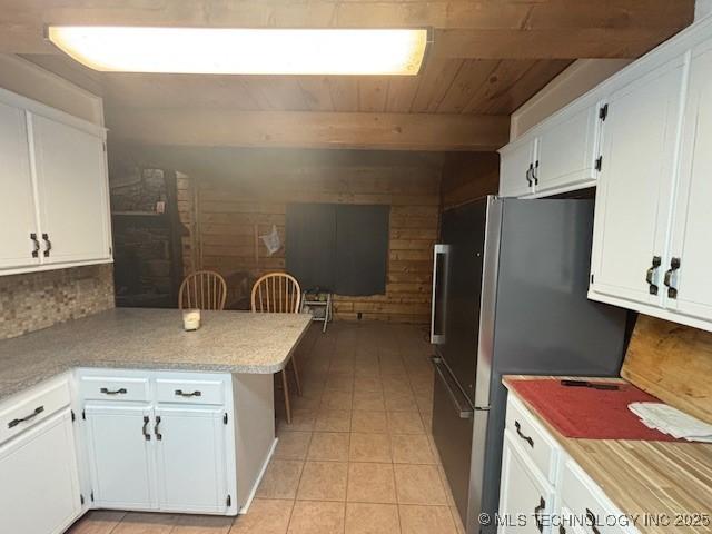 kitchen featuring white cabinets, light tile patterned floors, kitchen peninsula, and wooden ceiling
