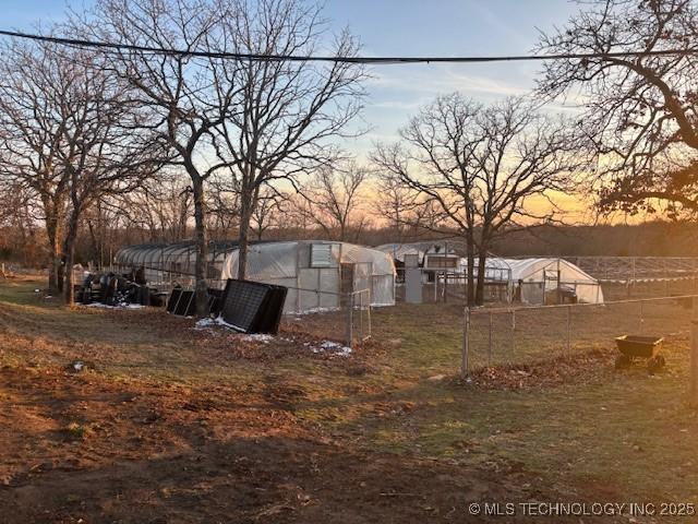 yard at dusk featuring an outdoor structure