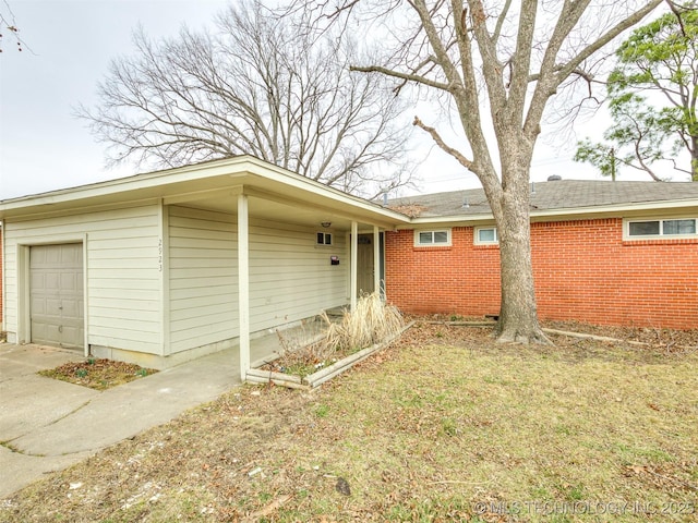 view of side of home featuring a garage and a lawn