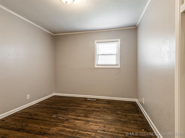 spare room featuring dark hardwood / wood-style flooring, ornamental molding, and a textured ceiling