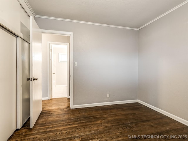 unfurnished bedroom with dark hardwood / wood-style flooring, crown molding, and a closet