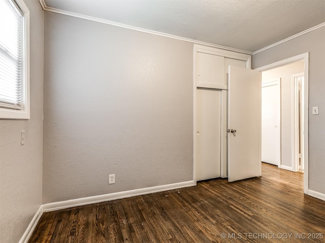 unfurnished bedroom featuring crown molding, dark hardwood / wood-style floors, and a closet