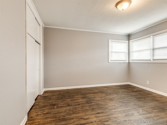 unfurnished bedroom featuring dark wood-type flooring, crown molding, a closet, and a textured ceiling