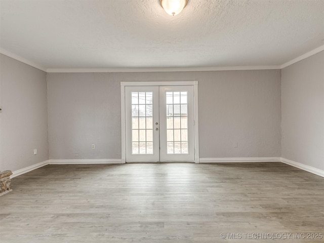 spare room with ornamental molding, a textured ceiling, light wood-type flooring, and french doors