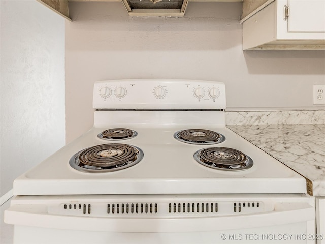 interior details with electric stove and white cabinetry