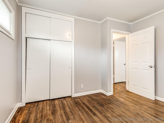 unfurnished bedroom with a closet, crown molding, and dark hardwood / wood-style floors