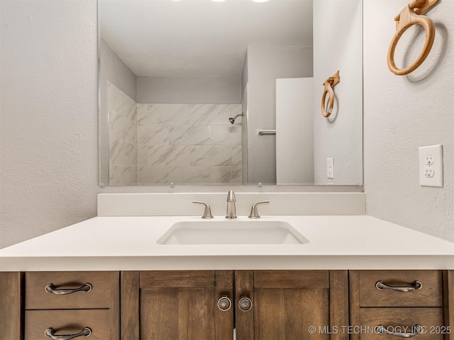 bathroom featuring vanity and tiled shower