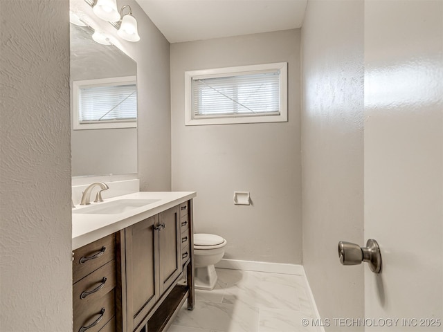 bathroom featuring vanity, plenty of natural light, and toilet