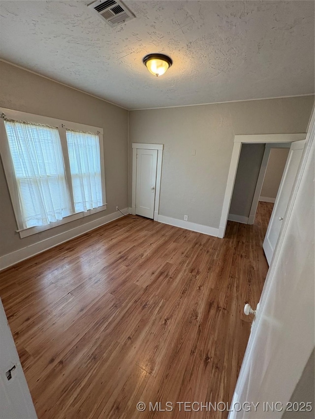 spare room with wood-type flooring and a textured ceiling