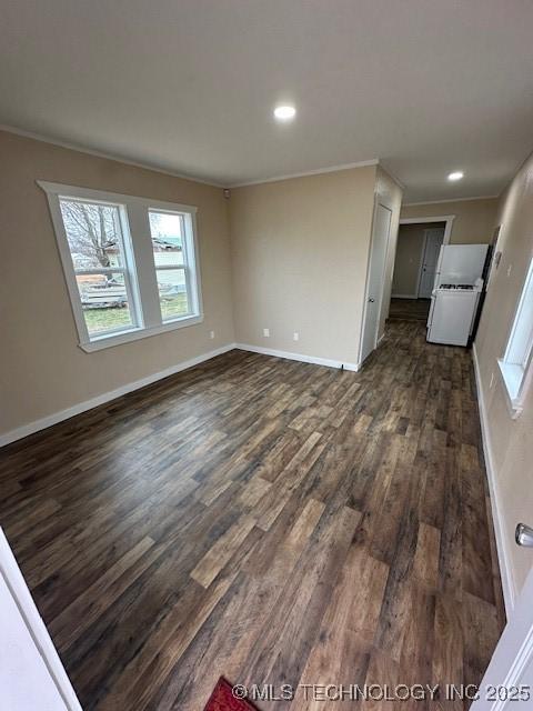 unfurnished living room featuring crown molding and dark wood-type flooring