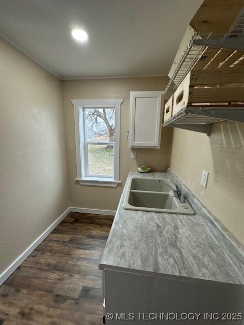 kitchen with sink, crown molding, dark wood-type flooring, and white cabinets