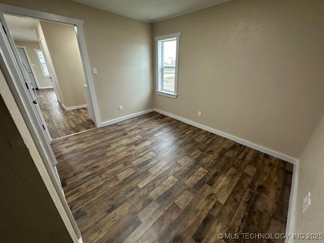 empty room with dark hardwood / wood-style flooring