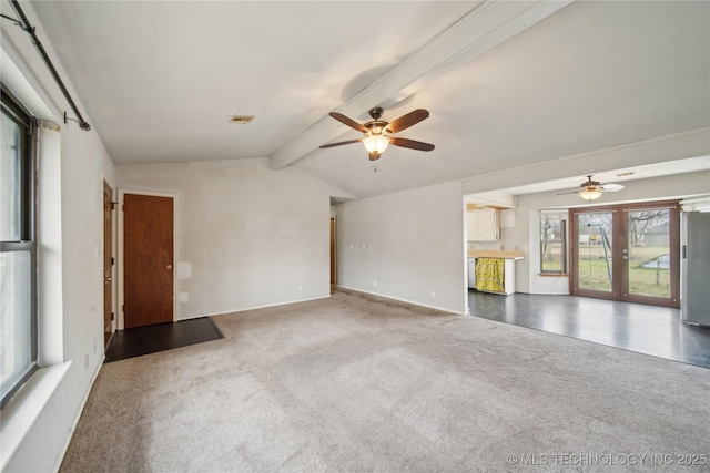 carpeted spare room featuring french doors, vaulted ceiling with beams, and ceiling fan