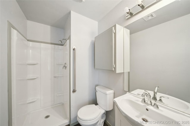 bathroom featuring vanity, toilet, and walk in shower