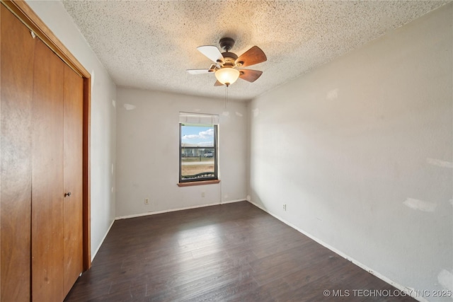 unfurnished bedroom with a textured ceiling, a closet, ceiling fan, and dark hardwood / wood-style flooring