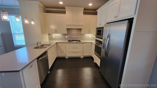 kitchen with stainless steel appliances, sink, white cabinets, and decorative light fixtures