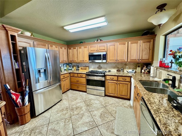 3 Huntly, Burneyville, OK 73430 - kitchen with light tile patterned floors, a sink, light stone countertops, backsplash, and stainless steel appliances