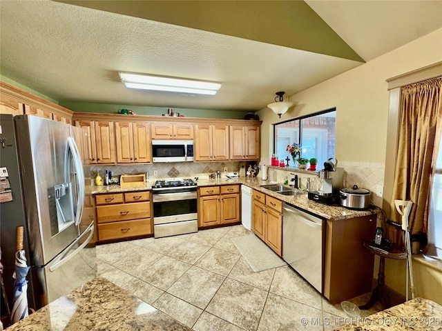 3 Huntly, Burneyville, OK 73430 - kitchen featuring a sink, appliances with stainless steel finishes, light stone countertops, backsplash, and light tile patterned flooring