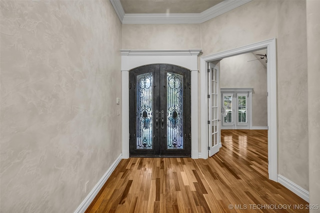 entrance foyer featuring crown molding, hardwood / wood-style flooring, and french doors