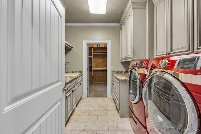 washroom with crown molding, cabinets, washer and clothes dryer, and sink