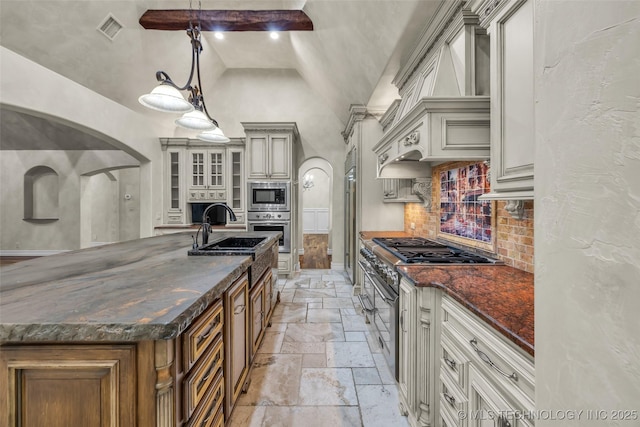 kitchen featuring stainless steel appliances, decorative light fixtures, sink, and dark stone countertops