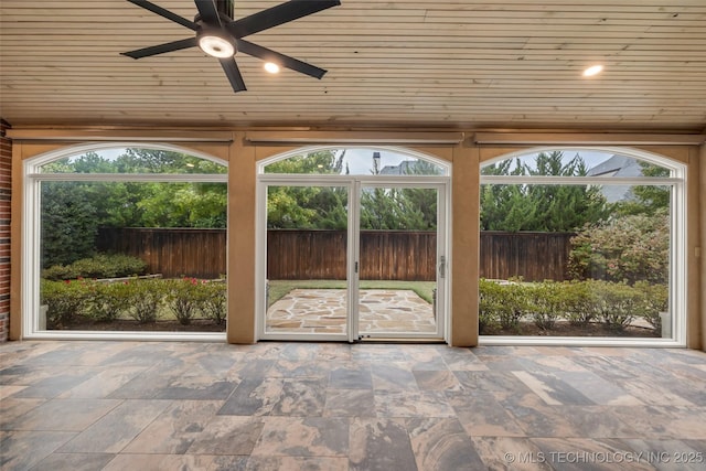 unfurnished sunroom with wood ceiling and ceiling fan