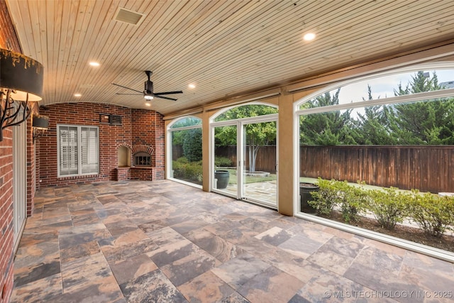 view of patio featuring a brick fireplace and ceiling fan