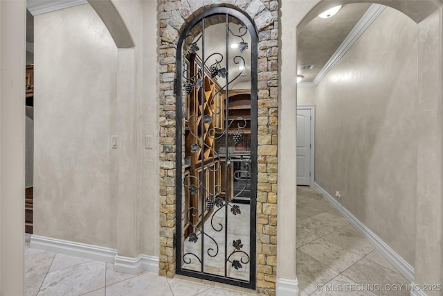 wine area with crown molding and light tile patterned floors